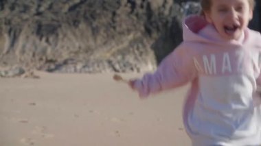 Okyanusu yöneten küçük bir çocuk, ılık bahar günü kumsalda koşuyor. Küçük beyaz bir kız, kumsalda koşuyor. Sevimli bir bayan.