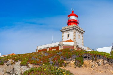 Cabo da Roca Deniz Feneri manzarası. Sintra, Portekiz. Portekiz Farol de Cabo da Roca Avrasya 'nın en batı noktasında bulunan bir pelerindir. Güneşli bir yaz günü. Bulutlu gökyüzü