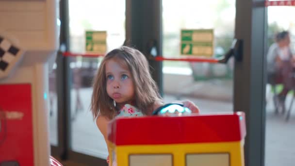 Pequena Menina Caucasiana Sentada Carro Elétrico Brinquedo Roda Canto Diversão — Vídeo de Stock