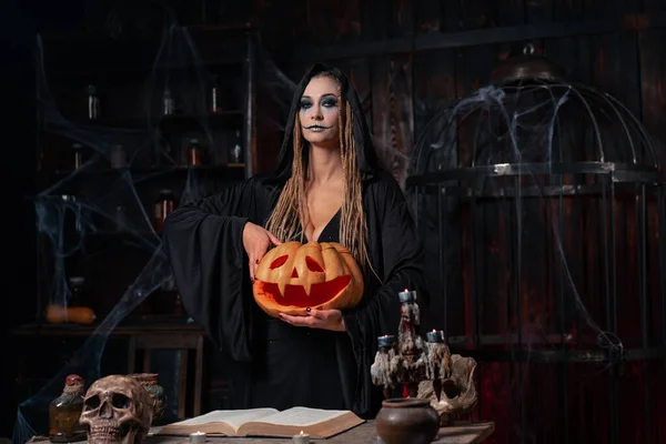 Концепция Хэллоуина Черная Ведьма Держит Тыкву Хэллоуин Вырезанным Улыбающимся Лицом — стоковое фото