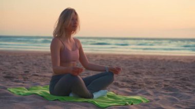 Kadın yoga nilüferinin yaz tatili kumsalında mutluluk ve rahatlama ile meditasyona poz vermesini sağlıyor. Sakin kadın yoga egzersizi okyanus sahillerinde altın gün batımında meditasyon yapar. Zen Akıl Sağlığı