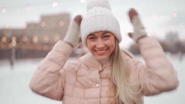 冬の街の幸せな大人の女性は冬服と白いニット帽を着ていた 正の原因アジアの女性の冬の屋外 クリスマス休暇のコンセプト 楽しい笑顔の人 — ストック動画