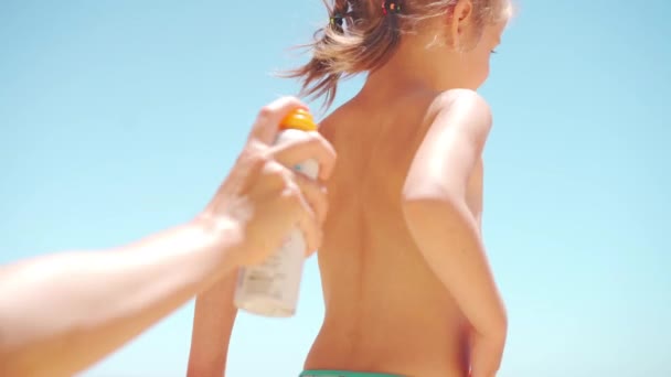 ケアの母親は背中と足に日焼け止めを適用します彼女の小さな娘 夏休みの海のビーチ 1人の子供が休んでいる白人の家族 太陽の保護クリーム Spf 幸せな子供時代正の感情 — ストック動画