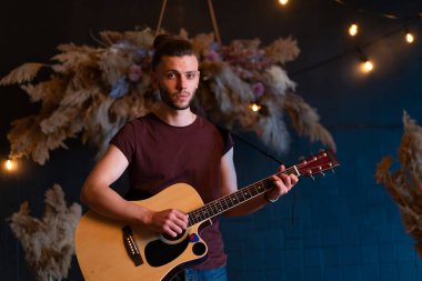 Erkek müzisyen akustik gitar çalıyor. Gitarist konserde klasik gitar çalıyor. Yakışıklı genç hippi gitarist özel bir parti veriyor. 