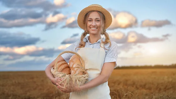 Woman baker holding wicker basket bread eco product Female farmer standing wheat agricultural field  Baking small business Caucasian person dressed straw hat apron organic healthy food concept Banner