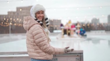 Kış zamanı. Winter City caddesinde kışın giyinmiş ve komik tüylü şapkalı mutlu yetişkin bir kadın. Beyaz, kadın, kışın açık havada. Noel tatili kavramı. Neşeli gülümseyen kişi. Kış günü