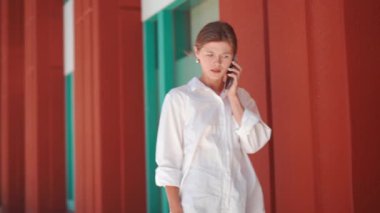 Sinirli bir iş kadını cep telefonuyla konuşuyor. Şok olmuş kız dışarıda telefonla konuşuyor. Üzgün iş kadını telefonda ciddi konuşuyor. Cep telefonundan kötü haber. İflas. Stresli, tatsız telefon.