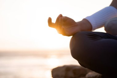 Kadın yoga nilüferinin yaz tatili kayalık plaj mutluluğu ve rahatlığı ile meditasyona poz vermesini sağlıyor. Yogayla sakin kadın egzersizleri okyanus sahilinde altın günbatımında meditasyon yapar. Zen Akıl Sağlığı
