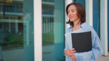 Businesswoman successful woman business person walking outdoor corporate building exterior Excited happy cute caucasian positive professional business woman holding folder documents Slow motion. 