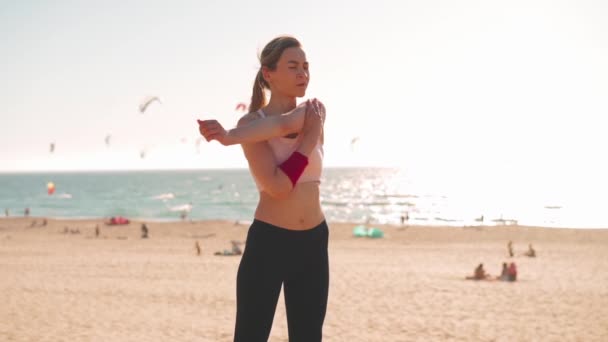 柔韧的高加索女孩在紧张的跑步训练后伸出手来 运动女性中年在户外运动前热身 夏天穿着运动衫在海滨穿衣 — 图库视频影像
