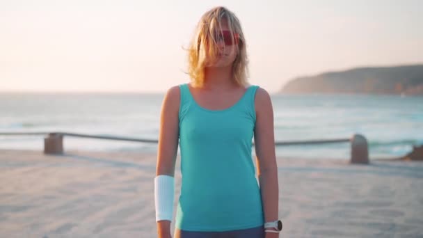 운동하는 코카서스 자연의 바닷가에 자신감 얹었다 운동복을 선글라스를 — 비디오