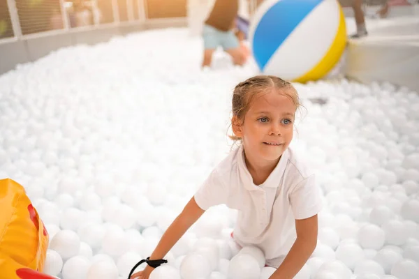 Happy Little Girl Playing White Plastic Balls Pool Amusement Park — стоковое фото