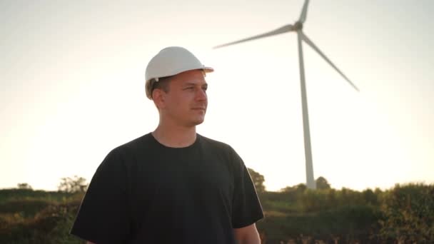 Engineer Man White Hard Hat Walking Field Huge Windmills Summer — Video Stock
