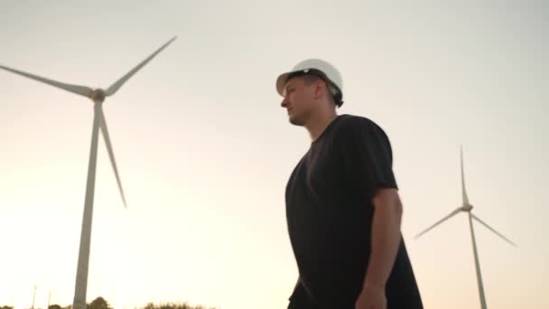 Engineer Man White Hard Hat Walking Field Huge Windmills Summer — Stockvideo