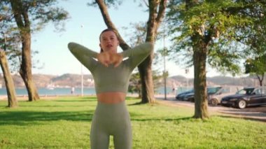 Woman Stretching And Warming-Up Before Running. Fit sport woman stretching her body warm up before workout outdoor. The girl in sportswear exercises outside in summer park for health and wellbeing. 