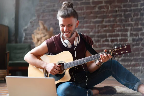 Caucasian young adult learning guitar online music class with distant teacher computer mobile device. Handsome hipster man teaching music through laptop, distance education learning concept