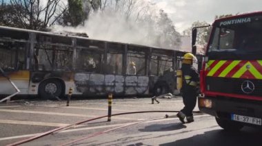 Portugal, Odivelas 07 September 2022 Rescue Team of Firefighters Arrive on the Car Crash fired passenger bus Traffic Accident Scene. Firemen fire department fight with fire on road. Accident disaster