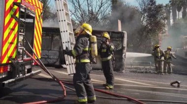 Portugal, Odivelas 07 September 2022 Rescue Team of Firefighters Arrive on the Car Crash fired passenger bus Traffic Accident Scene. Firemen fire department fight with fire on road. Accident disaster