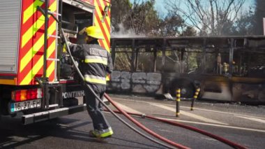 Portugal, Odivelas 07 September 2022 Rescue Team of Firefighters Arrive on the Car Crash fired passenger bus Traffic Accident Scene. Firemen fire department fight with fire on road. Accident disaster