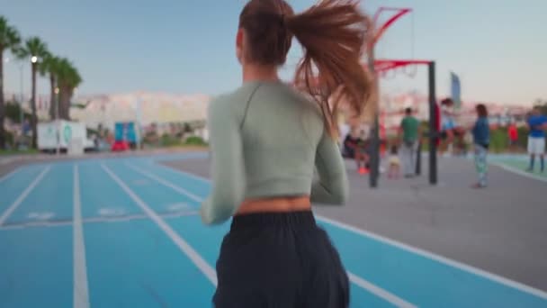 Női Atléta Fut Pályán Közelében Sportpálya Visszapillantás Alkalmas Kaukázusi Fiatal — Stock videók