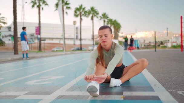 Läuferinnen Machen Dehnübungen Sitzend Auf Der Laufstrecke Junge Sportlerin Sitzt — Stockvideo
