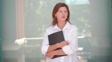 İş kadını video portresi. Kafkas kadın işadamı dışarıda kağıt tutacağı ile duruyor. Genç, güzel, modern, 30 'lu yaşlarda bir iş kadını. Güvenilir işveren 