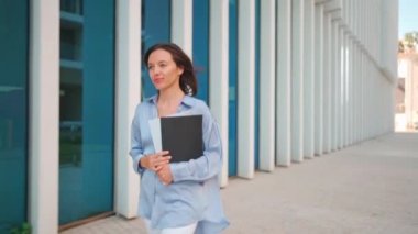 Businesswoman successful woman business person walking outdoor corporate building exterior Excited elegance cute caucasian confidence professional business woman holding folder documents Slow motion. 
