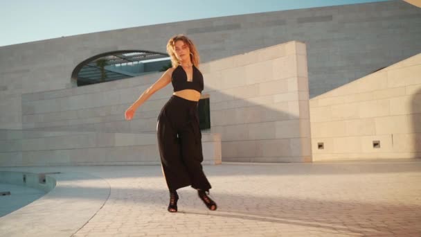 Γυναίκα Της Μόδας Σγουρά Μαλλιά Ντυμένη Στα Μαύρα Χορεύει Έξω — Αρχείο Βίντεο