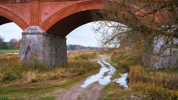 Lengkungan Bawah Jembatan Berliku Liku Jalan Kerikil Bawahnya Genangan Air — Stok Foto
