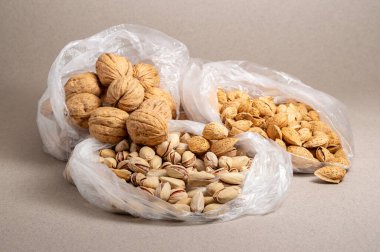 Açık plastik torbalarda çeşitli fındıklar.