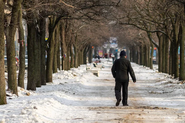 Hátsó kilátás egy férfi sétál a téli sikátorban — Stock Fotó