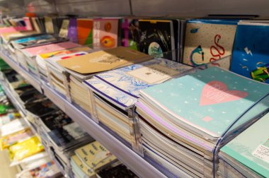 Kırtasiyenin rafında çeşitli kopya kitapları var.