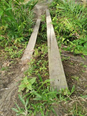 Kanalizasyon yolunu geçmek için basit iki parça tahta köprü.