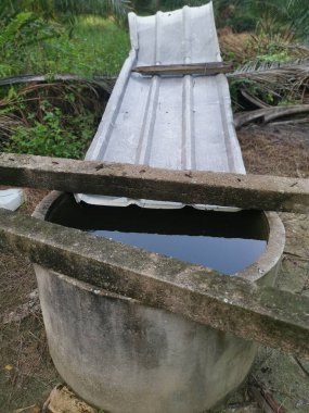 Çini çarşaflı beton duvar çiftlikte yağmur suyu toplamak için.