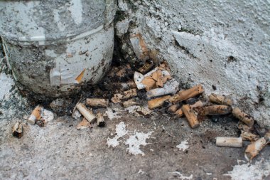 Kaldırım kenarında sigara izmaritleri..