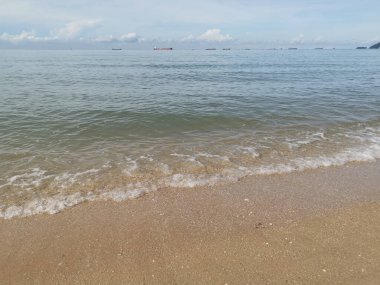 Deniz dalgalarının kumlu sahile doğru ilerlediği sahne