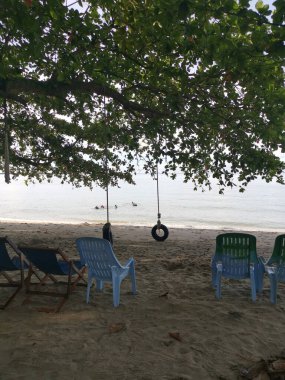 Perak, Malezya - Kasım 12021: Teluk Batik Tatil Köyü 'ndeki egzotik plajda dinlenen insanların eğlence faaliyetleri.