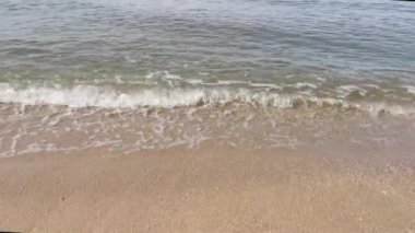 Deniz dalgalarının kumlu sahile doğru ilerlediği sahne