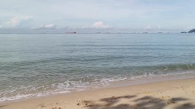 Deniz dalgalarının kumlu sahile doğru ilerlediği sahne