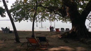 Perak, Malezya - Kasım 12021: Teluk Batik Tatil Köyü 'ndeki egzotik plajda dinlenen insanların eğlence faaliyetleri.