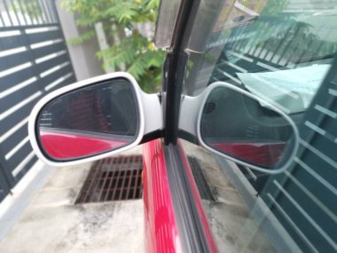 Yansıtıcı araba yan ayna parkı caddenin yanında.