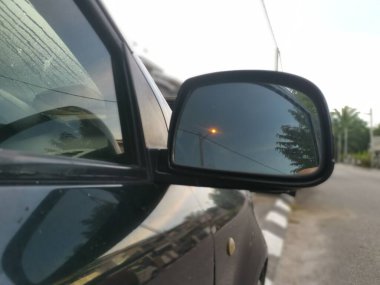 Yansıtıcı araba yan ayna parkı caddenin yanında.