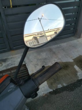 Yansıtıcı araba yan ayna parkı caddenin yanında.