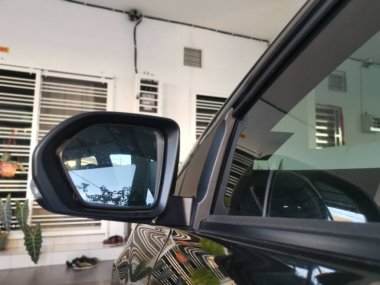 Yansıtıcı araba yan ayna parkı caddenin yanında.