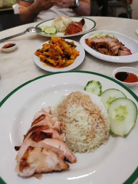 famous chicken rice the staple food of Malaysia with mixed vegetable and crispy sliced fried pork.