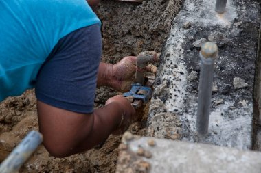 Su tesisatı işçisi sızıntıdan kaynaklanan ferruat vanası borusunu tamir ediyor..