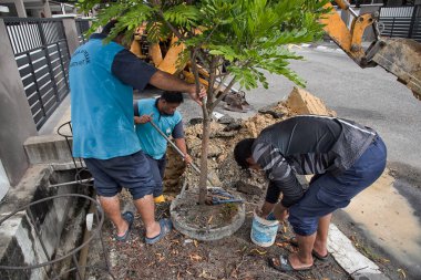 Perak, Malezya. 1 Aralık 2021: Taman Mas 1, Kampong Koh 'un yol kenarındaki sızıntıdan kaynaklanan su ferruat kapakçığı borusunu tamir eden su işçisi.