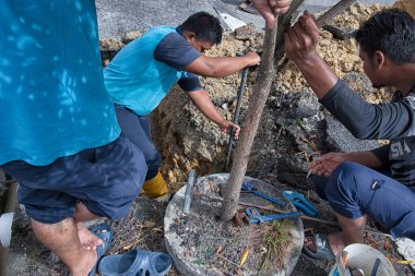 Perak, Malezya. 1 Aralık 2021: Taman Mas 1, Kampong Koh 'un yol kenarındaki sızıntıdan kaynaklanan su ferruat kapakçığı borusunu tamir eden su işçisi.