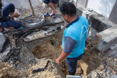 Perak, Malezya. 1 Aralık 2021: Taman Mas 1, Kampong Koh 'un yol kenarındaki sızıntıdan kaynaklanan su ferruat kapakçığı borusunu tamir eden su işçisi.