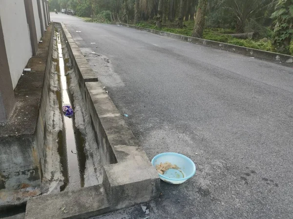 Evsiz hayvanları beslemek için yol kenarındaki açık mavi plastik kase..